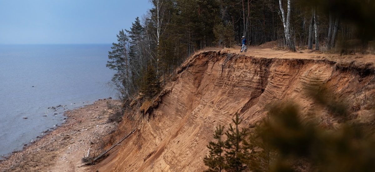 a person standing on top of a cliff next to the ocean