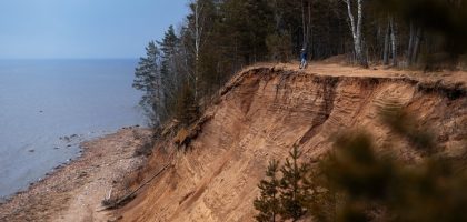 a person standing on top of a cliff next to the ocean