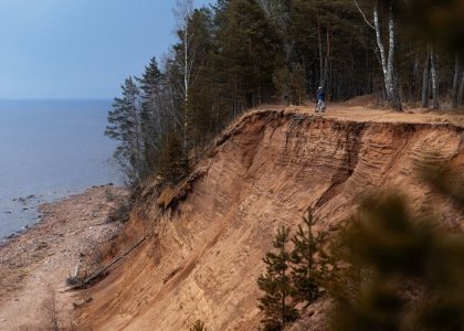 a person standing on top of a cliff next to the ocean